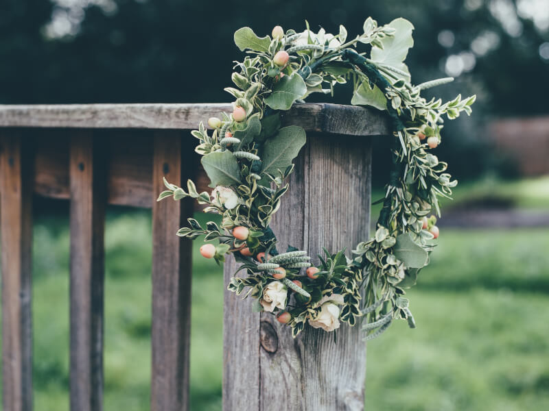 A flower crown resting on the side of a wooden bench